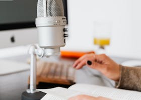 pexels-photo-4476138-4476138 Hands holding a book near a microphone, perfect for recording or podcast scenes.